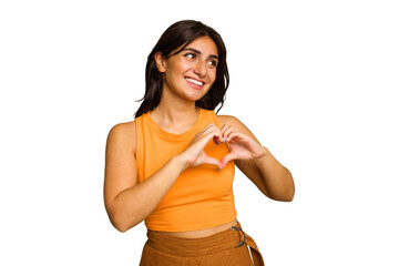 Young Indian woman isolated on green chroma background smiling and showing a heart shape with hands.
