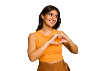 Young Indian woman isolated on green chroma background smiling and showing a heart shape with hands.