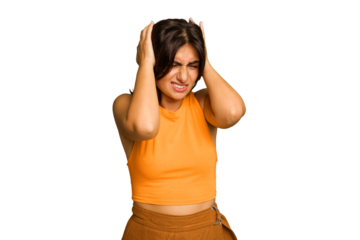 Young Indian woman isolated on green chroma background covering ears with hands.