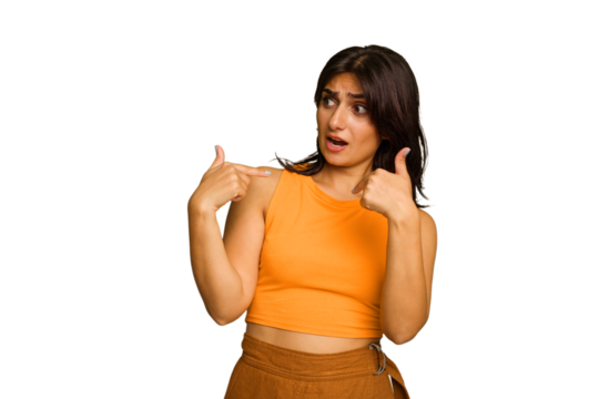Young Indian woman isolated on green chroma background surprised pointing with finger, smiling broadly.