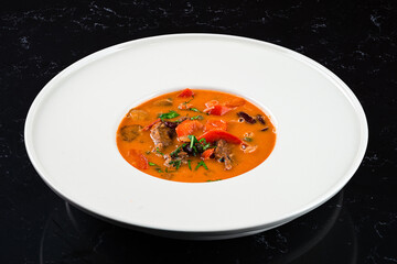 Asian Tom Yam soup with shrimps, coconut milk, tomatoes, lemongrass, mint and cilantro