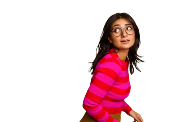 Young Indian woman isolated on green chroma background looks aside smiling, cheerful and pleasant.