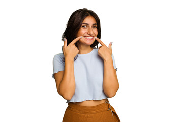 Young Indian woman isolated on green chroma background smiles, pointing fingers at mouth.
