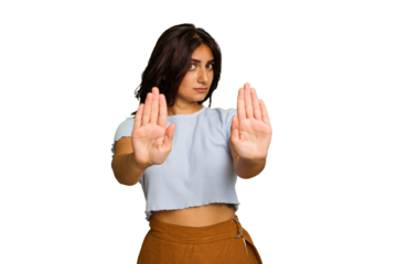 Young Indian woman isolated on green chroma background standing with outstretched hand showing stop sign, preventing you.