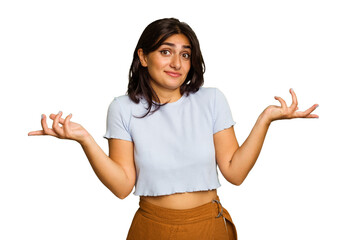 Young Indian woman isolated on green chroma background doubting and shrugging shoulders in...