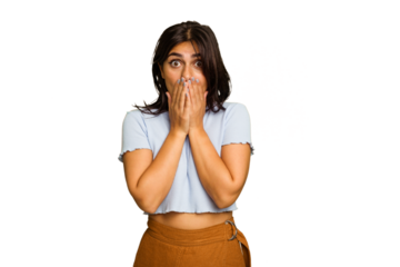 Young Indian woman isolated on green chroma background shocked covering mouth with hands.