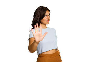 Young Indian woman isolated on green chroma background rejecting someone showing a gesture of...