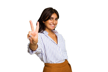 Young Indian woman isolated on green chroma background joyful and carefree showing a peace symbol...