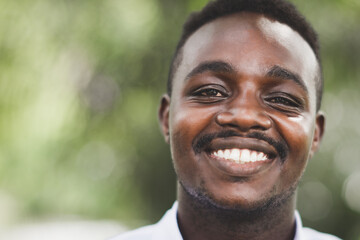 A charming african man with a happy face standing and smiling with a confident smile showing teeth