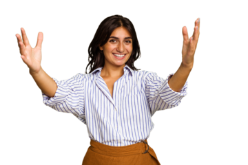 Young Indian woman isolated on green chroma background celebrating a victory or success, he is surprised and shocked.