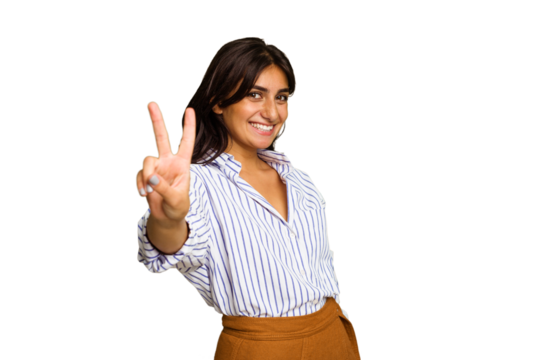 Young Indian woman isolated on green chroma background joyful and carefree showing a peace symbol with fingers.