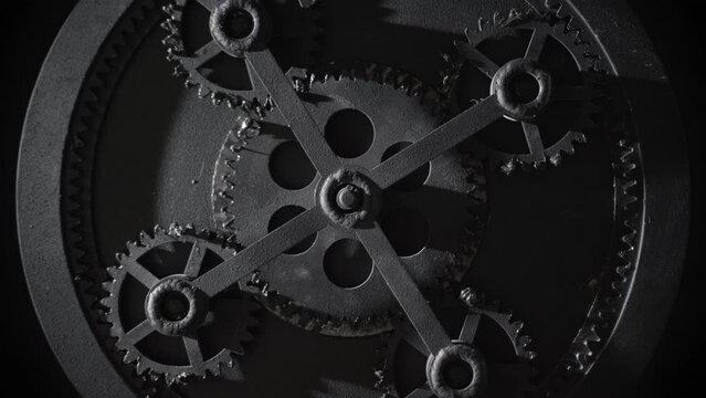 Retro mechanism with five rotating gears. Vintage cogwheels of machine in ancient old factory. Moving engine parts and internal details, steampunk concept. Isolated on black, zoom in
