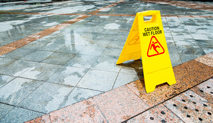 Yellow wet floor warning sign on the floor