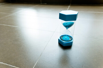 Modern hourglass on tiled floor