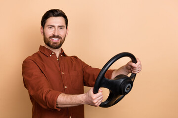 Portrait of positive person hands hold steer wheel toothy beaming smile isolated on beige color background