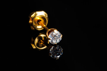 Jewelry with stones earrings, luxury golden earrings with diamonds, jewels on a black background.