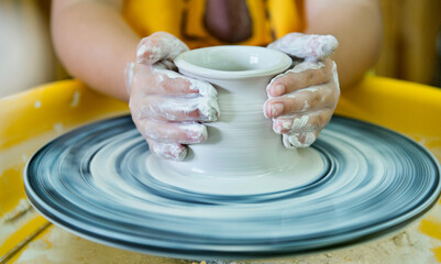 Young boy making a pitcher of clay