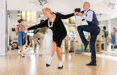 Mature woman learning to dance lindy hop with younger man