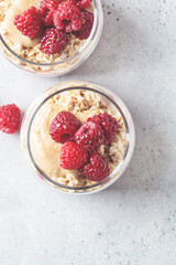 Overnight oatmeal with raspberries, currants and tahini in jars. Breakfast concept.