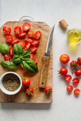 Fresh summer tomatoes, leaves of green basil, and olive oil.