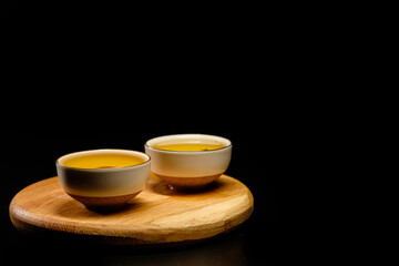 Traditional japanese, chinese asian tea ceremony concept. White ceramic tea cups with lotus on black background. Copy space.
