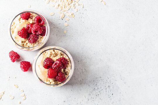 Overnight oatmeal with raspberries, currants and tahini in jars. Breakfast concept.