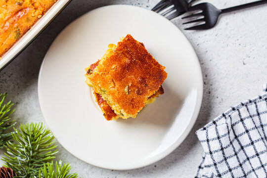 Portion of Christmas cheddar cornbread on white plate, close-up. Festive recipe food concept.