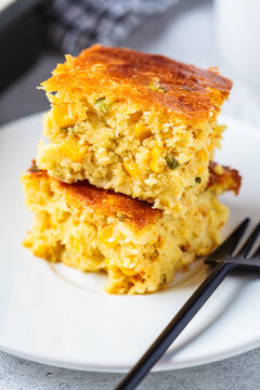 Portion of Christmas cheddar cornbread on white plate, close-up. Festive recipe food concept.