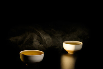 Two cups of chinese tea  with steam isolated on black background. Top view