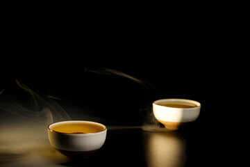 Two cups of chinese tea  with steam isolated on black background. Top view