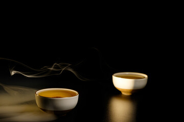Obraz na płótnie Canvas Two cups of chinese tea with steam isolated on black background. Top view