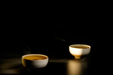 Obraz na płótnie Canvas Two cups of chinese tea with steam isolated on black background. Top view