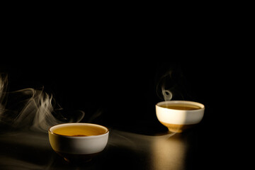 Two cups of chinese tea  with steam isolated on black background. Top view