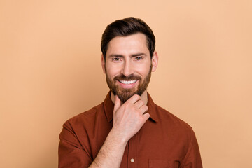 Portrait of positive friendly person arm touch chin toothy smile thinking isolated on beige color background