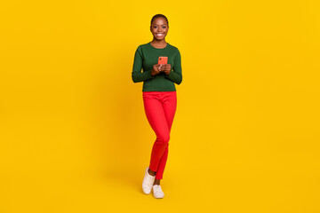 Naklejka na ściany i meble Full length photo of funky adorable woman wear green shirt typing modern device isolated yellow color background