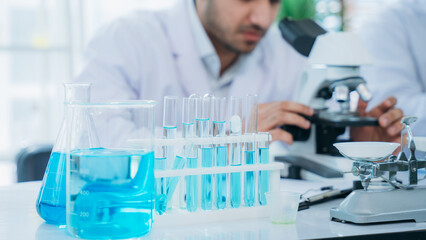 A microscope is being used for research in the lab by the group of young scientists.