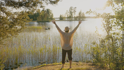 Fototapeta na wymiar Young man runs to river bank and jumps with happiness