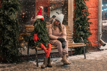 Obraz premium Pretty woman with fir tree decorated mannequin. Xmas holidays, New Year or Christmas concept