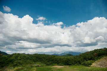 Green mountain landscape with white clouds