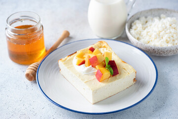 Cottage cheese casserole Zapekanka with peach, sour cream and honey. Sweet breakfast cheese cake