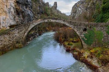 Fototapeta na wymiar Kokori's old arch stone bridge (Noutsos) during fall season situated on the river of Voidomatis in Zagori, Epirus Greece.