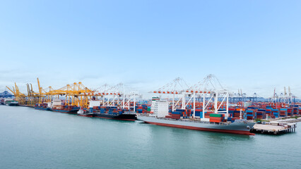 Fototapeta premium Container ship loading and unloading in commercial port, business service of goods logistic import and export freight transportation by container ship in sea,