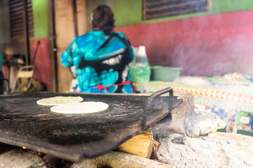 Latin woman from Nicaragua from behind making tortillas