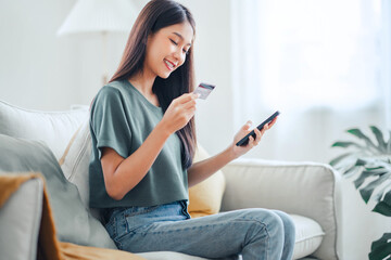 Obraz premium Online payment, Happy asian woman holding a credit card and using smart phone for online shopping