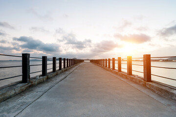 Concrete path to the sea at sunset.