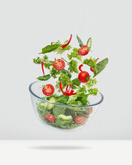 Lettuce falling into a glass salad bowl. Healthy food, diet. Levitating salad..