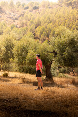 Man in cap and red t-shirt admiring the natural landscape.