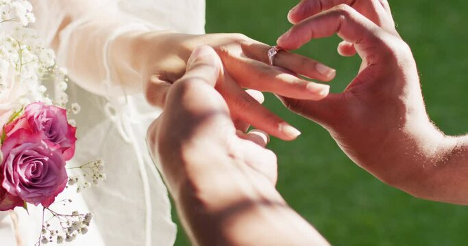 Close up of married african american couple putting ring