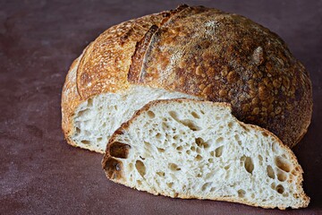 Fresh homemade sourdough bread with whole grain flour on a on a brown background. Healthy food.