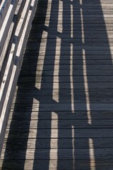 Fototapeta premium Boardwalk and railing with shadows in low afternoon lighting